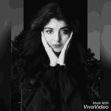a black and white photo of a woman covering her face with her hands