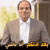 a man in a suit and a white shirt with arabic writing on it