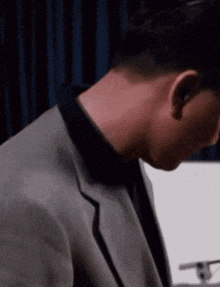 a man in a suit and tie is looking down