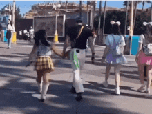 a group of people are walking down a street and one of them has a backpack that says disney on it