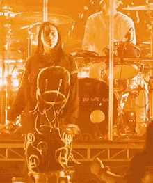 a woman stands in front of a drum set with a shirt that says do we go