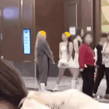 a blurry picture of a group of people including a woman in a red shirt and a woman in a white dress
