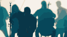 a group of people are silhouetted against a blue sky