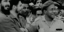 a black and white photo of a group of men standing next to each other in a crowd .