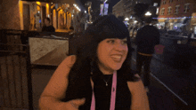a woman wearing a black top and a pink lanyard that says shangarita