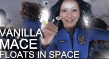 a woman in a space suit holding a flower with the words vanilla mace floats in space