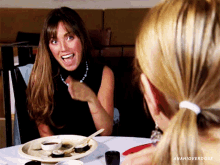 a woman is sitting at a table with a plate of food and the words anahioverdose above her