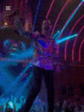 a man in a colorful shirt is singing into a microphone in front of a crowd with the word zapcut on the bottom right