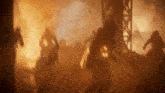 a group of people are standing in front of a large fire .