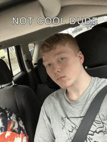 a young man is sitting in the back seat of a car with the words " not cool dude " above him