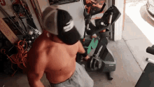 a man without a shirt is standing next to a life fitness bike