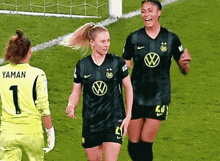 a soccer player named yaman stands on the field with her teammates