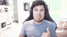 a man wearing headphones giving a thumbs up sign