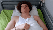 a young man with curly hair is laying in a hospital bed