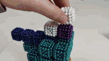 a person is playing with a bunch of beads including purple and white ones