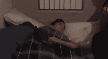 a group of people standing around a bed with a man laying on it