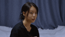 a woman wearing a black t-shirt that says nbc smiles for the camera