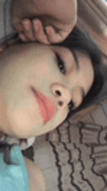 a close up of a person 's face with a hand on their head .