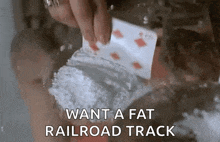 a person is holding a playing card and a bag of cocaine in their hand .