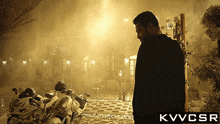 a man standing in front of a motorcycle with the letters kvvcsr on the bottom