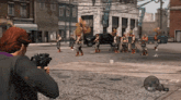 a man is holding a gun in front of a group of people in a video game with the number 30 on the screen