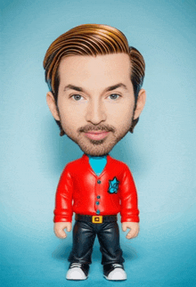 a figurine of a man with a beard is wearing a red cardigan