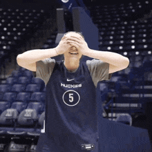 a man in a huskies jersey covering his eyes