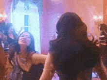 a woman in a black dress is dancing in front of a mirror