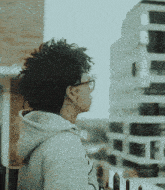 a person wearing glasses and a hoodie with the number 5 on the back