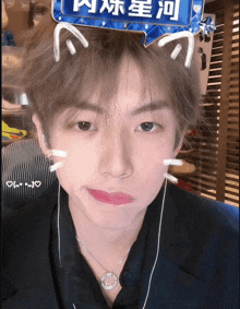 a boy wearing a cat ear headband with chinese writing