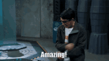 a man is standing in a room with the words amazing on the screen