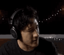 a man wearing headphones and a black shirt is making a funny face .