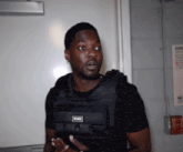 a man is wearing a black vest with the word hurik on it