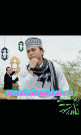 a man wearing a scarf and a hat is surrounded by lanterns and the word ramadan is on the bottom of the image