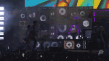 a man playing a guitar and another man playing a guitar on stage
