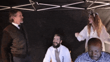 a man in a suit and tie stands next to a man in a white lab coat