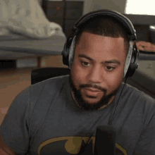 a man is wearing headphones and a batman shirt