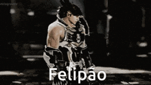 a man is standing in a dark room with the word felipao written on the bottom .