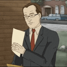 a man in a suit and tie is holding a piece of paper in his hands