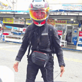 a man wearing a hjl helmet is standing in front of a store