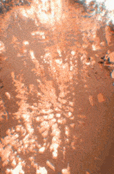 a close up of a brown colored surface with a few pieces of ice on it