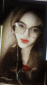 a woman wearing glasses and headphones looks at the camera with a blurry background