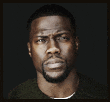 a man with a beard is looking at the camera with a serious look on his face