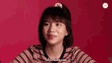 a girl in a red and white striped shirt is talking in a language other than english