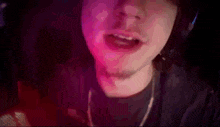 a close up of a person 's face with a pink light behind them .