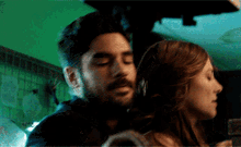a man and a woman are hugging each other in a dark room