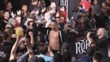 a man stands in front of a crowd with a sign that says ring of honor on it