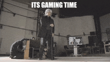 a man in a suit is standing in a room with the words its gaming time written above him