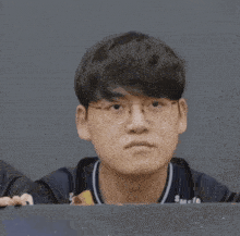 a man wearing glasses making a heart with his hands