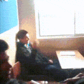 a blurry picture of a man sitting at a table with a laptop